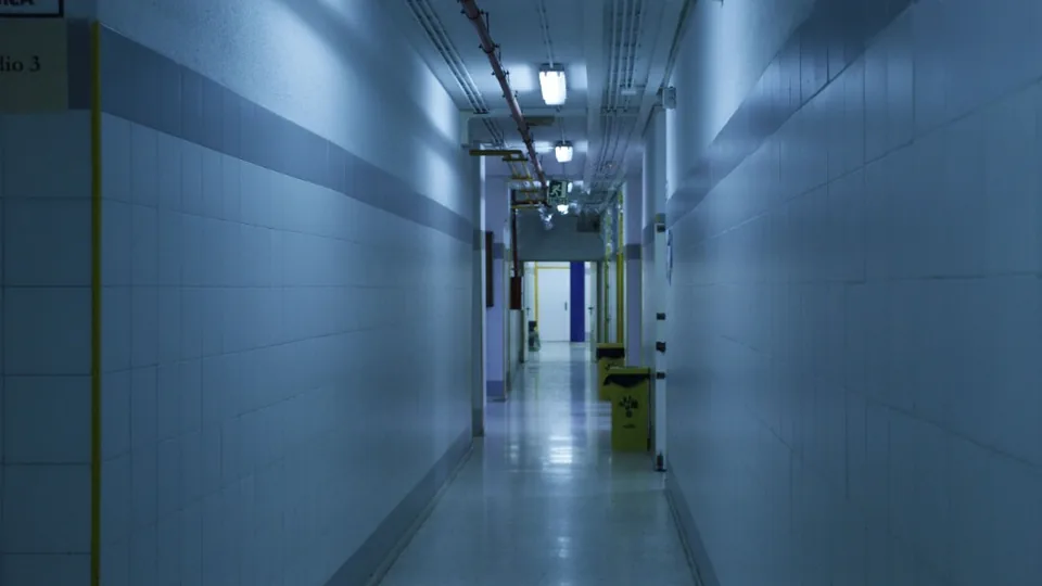 Institutional corridor with an emergency exit sign overhead